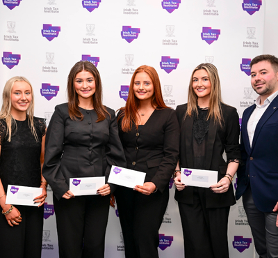 Photo of 1st Place Fantasy Budget team from UCC in front of the Irish Tax Institute logo